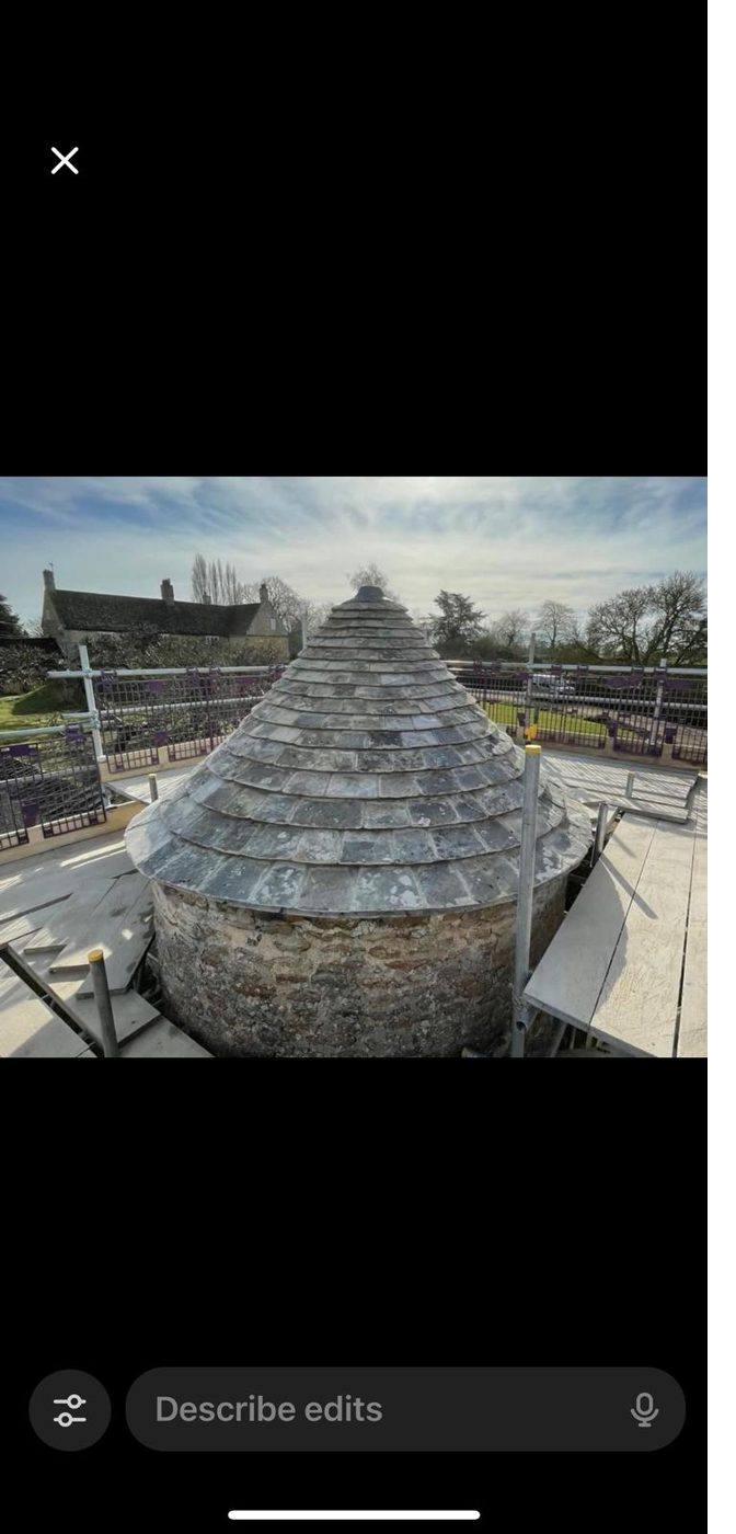 The conical slate roof of a medieval dovecote.