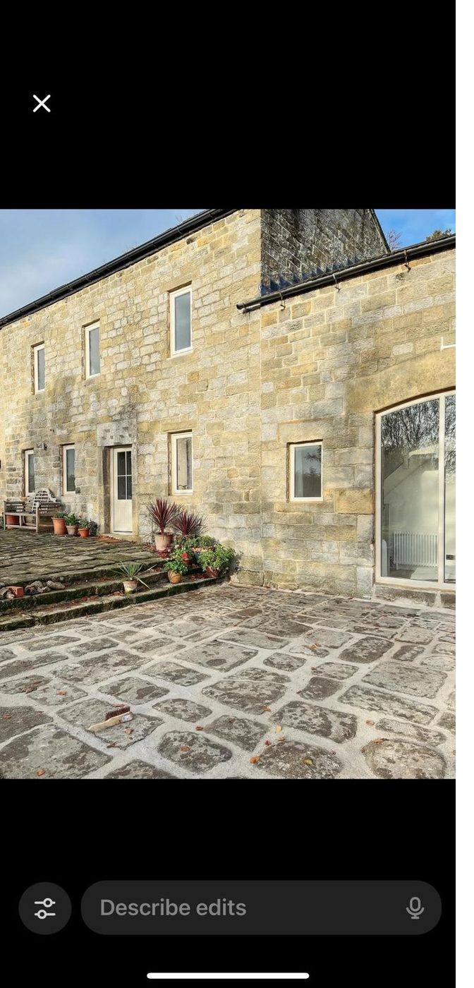 A restored sandstone farmhouse with stone-sett courtyard.